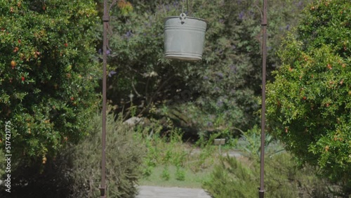 This tilting video features a wishing well in a garden.  photo