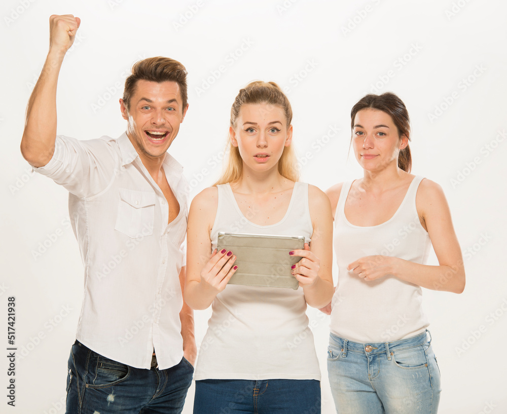 Obraz premium team of young business people in white shirts on a white background isolated. a team of two girls and a guy is happy, wins, plans, argues, discusses, gets upset, wins something. close-up portrait 