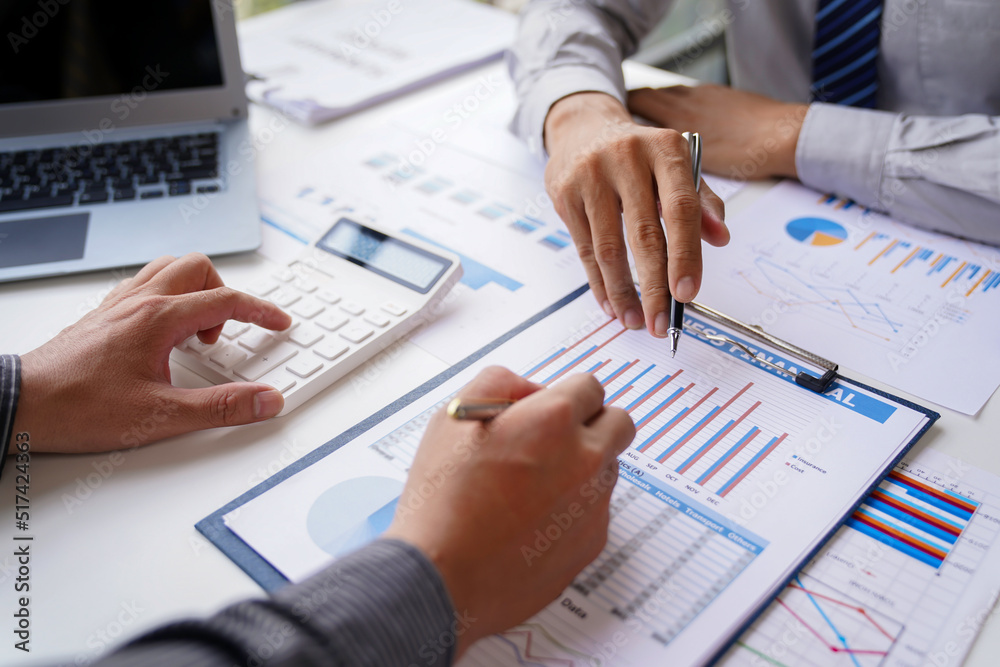 Teamwork, analyze, Business meeting.business team brainstorming discussing with paper graph chart in the office while sitting at the office table together Teamwork, analyze, Business meeting.business team brainstorming discussing with paper graph chart in the office while sitting at the office table together