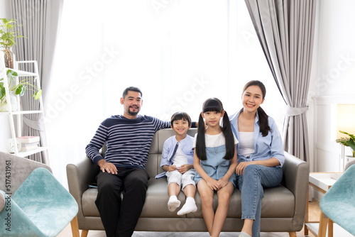 Portrait of asian family mother father and kids at home on sofa in living room.happy family concept.