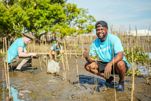 African American men volunteer helpers planting trees in mangrove forest for environmental protection and ecology, reduce global warming, Charity work photo