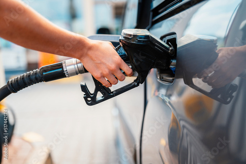 Photo Closeup of woman pumping gasoline fuel in car at gas station