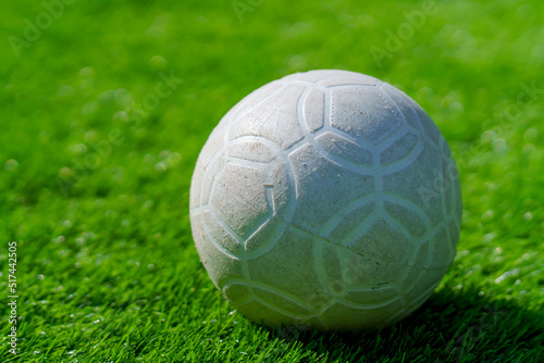 plastic football ball on the green grass of artificial lawn background