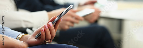 Female hands with manicure hold mobile phone device