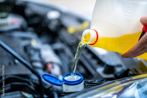 Pouring antifreeze. Filling a windshield washer tank with an antifreeze in summer hot weather. photo