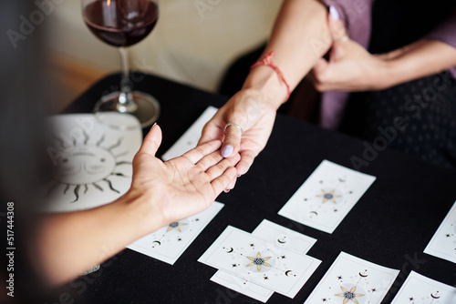 Obraz na plátně Fortune teller asking young woman to give her hand for palm reading