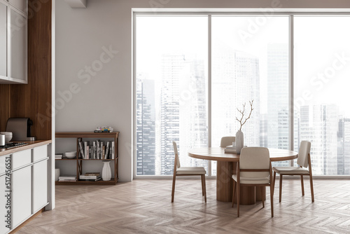 Light kitchen interior with eating table and chairs  kitchenware and window