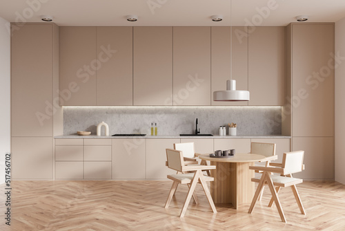 Light kitchen interior with eating table and seats on wooden floor
