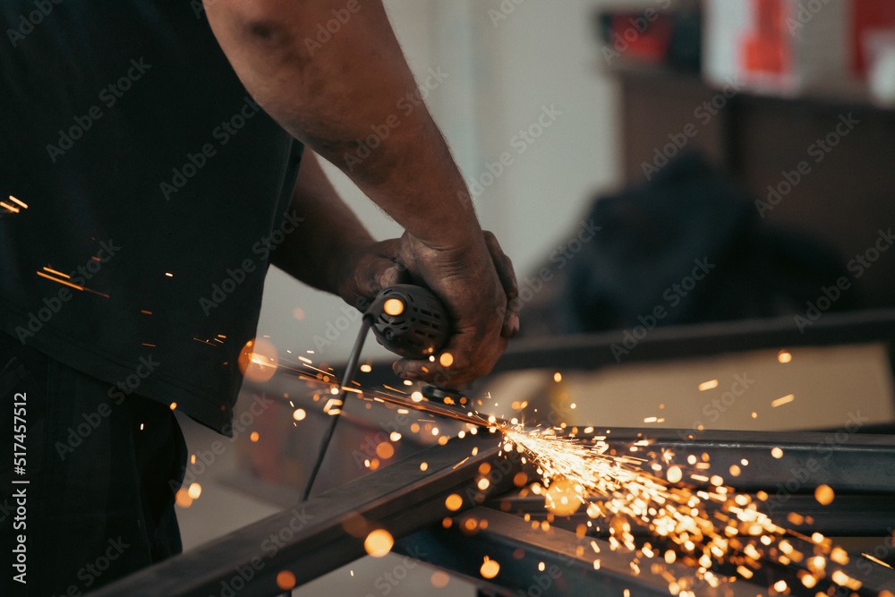 Close up on a man held an angle grinder to cut an iron with sparks Close up on a man held an angle grinder to cut an iron with sparks