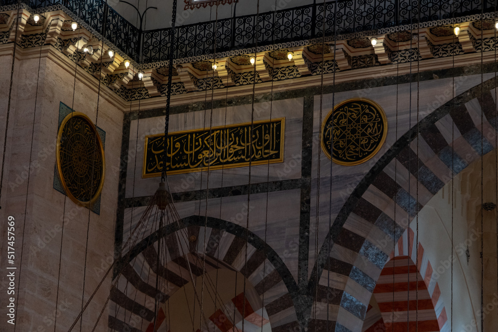 Obraz premium Interior of Suleymaniye Mosque, Quran text on green plates in mosque, beautiful wall decorations, low brightness historical Islamic building