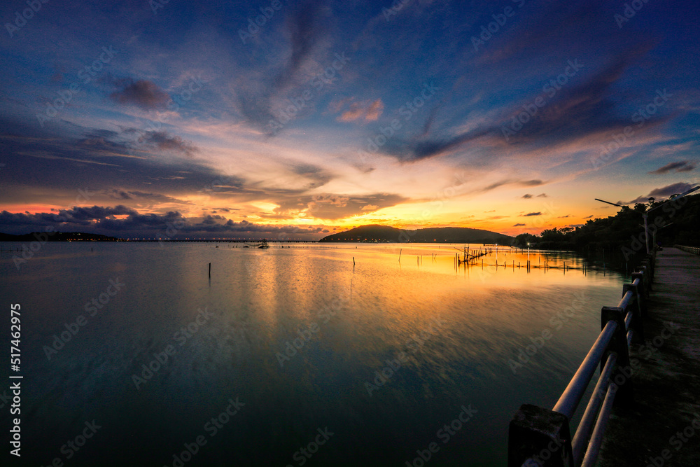 Obraz premium The background of the sea by the evening sea, with natural beauty (sea water, rocks, sky) and fishermen are fishing by the river bank, is a pleasure during travel.