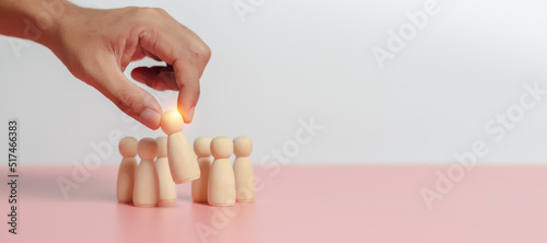 Leadership of teamwork concept. Wooden figures human was chosen leadership of teamwork. man's hands are select wooden puppet to devise strategies for appointing leaders. photo