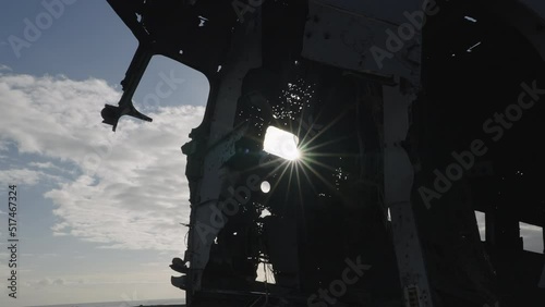 Crashed Plane Wreckage Silhouette Against the Sun. Solheimasandur Beach Iceland photo