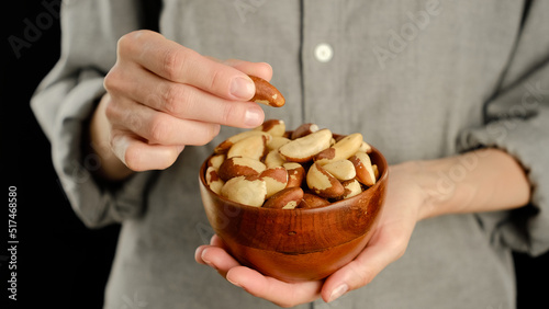 Female hold brazilian nuts in hand.