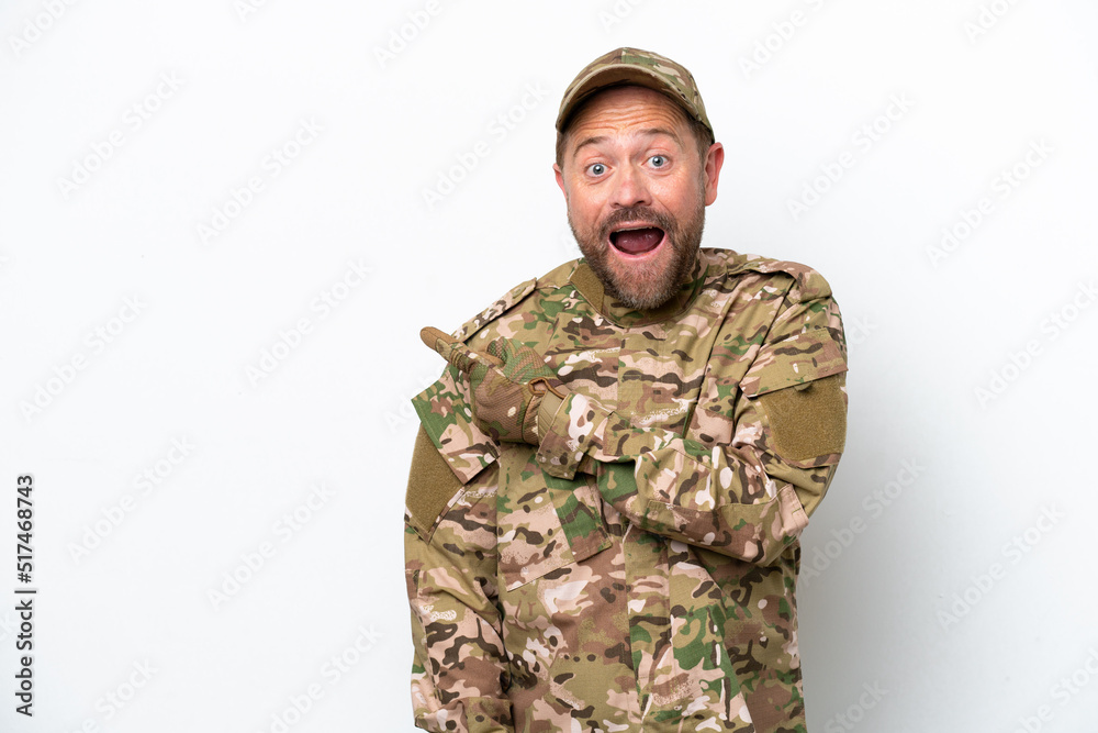 Military man isolated on white background surprised and pointing side Military man isolated on white background surprised and pointing side