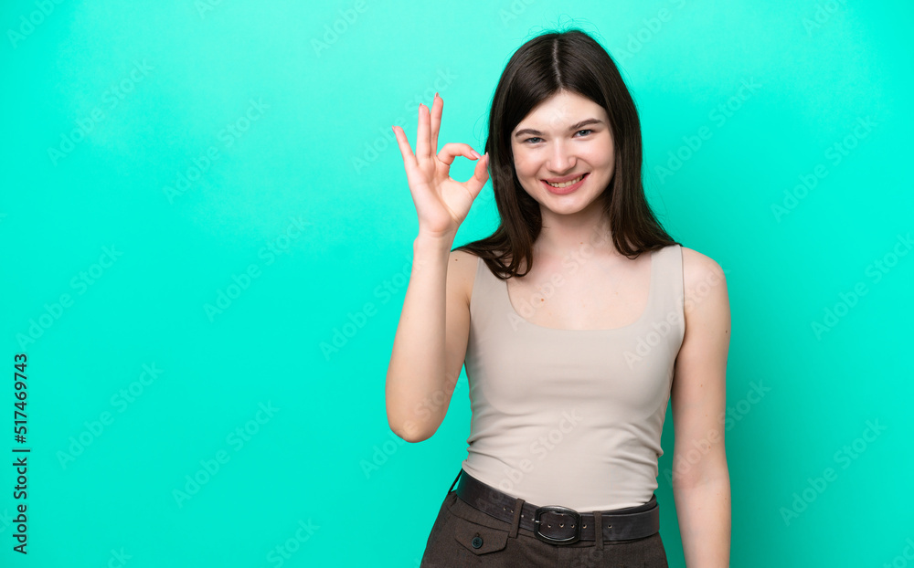 Fototapeta premium Young Russian woman isolated on green background showing ok sign with fingers
