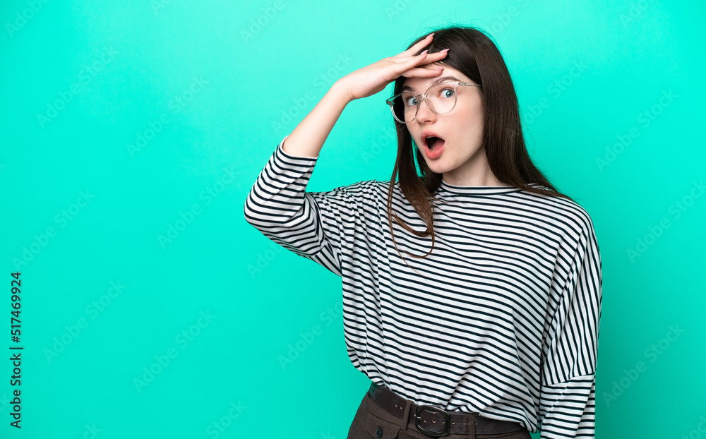 Young Russian woman isolated on green background doing surprise gesture while looking to the side Young Russian woman isolated on green background doing surprise gesture while looking to the side