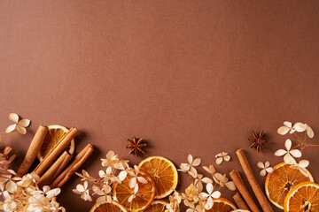 Autumn spice and flowers frame, border on brown background
