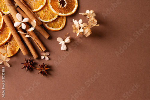 Fototapeta Naklejka Na Ścianę i Meble -  Autumn spice and flowers frame, border on brown background