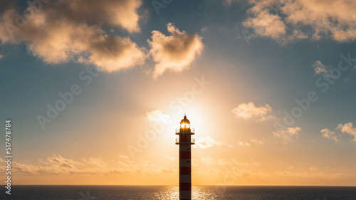 Landscape of the sky with a beautiful sunset and a lighthouse that illuminates the sea