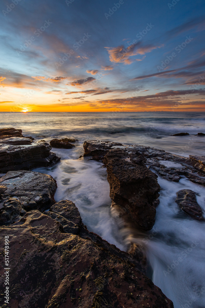 Beautiful sunrise view at rocky beach shore.