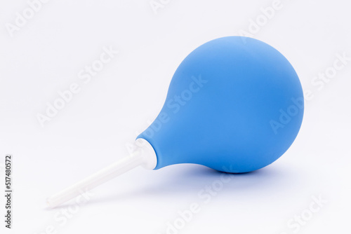 Enema for cleaning intestines and treating diseases of digestive system and cleaning body. Medical pear rubber blue enema on white background.