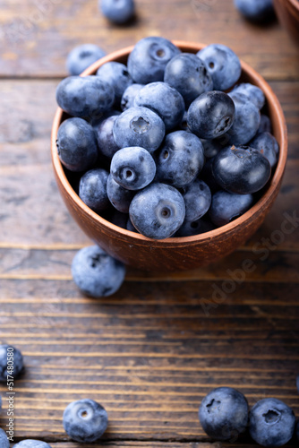 Freshly picked blueberries in  bowl. Bilberry on wooden Background. Blueberry antioxidant. Concept for healthy eating and nutrition