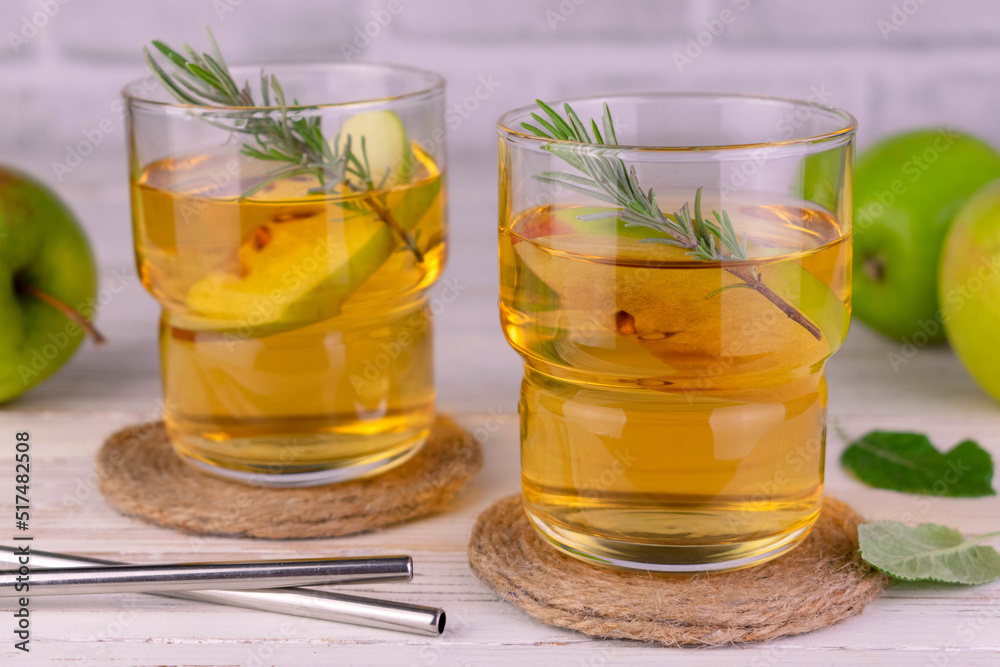 Juice from green apples in glasses with a sprig of rosemary.
Juice from green apples in glasses with a sprig of rosemary.
