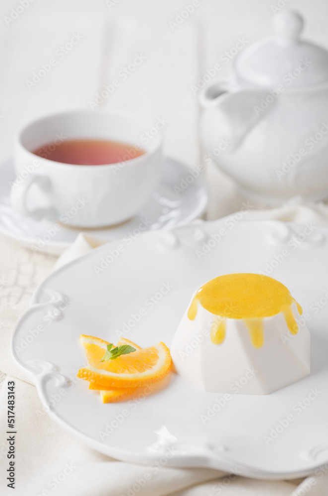Fototapeta premium Sweets cake orange soufflé with tea. Photo of food on a white background