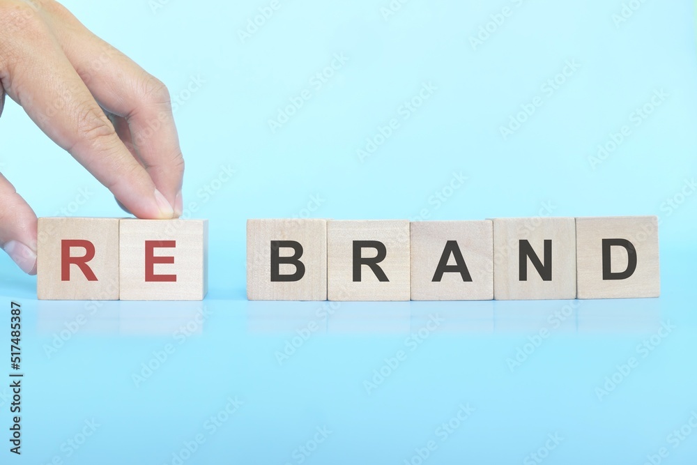 Business rebranding concept. Human hand changing the word brand to rebrand.