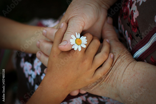 Grandmother and granddaughter hold hands together. The grandson's hands hold the wrinkled hand of an elderly grandmother. The concept of love and care. Gesture, a sign of support and love, care, unity
