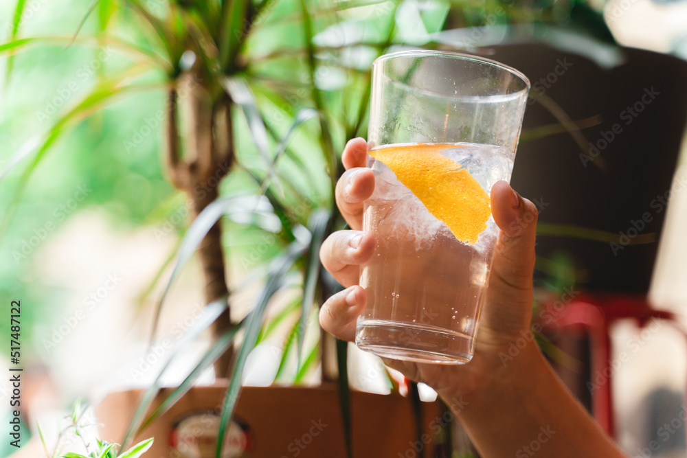 A close up of a hand holding gin and tonic A close up of a hand holding gin and tonic