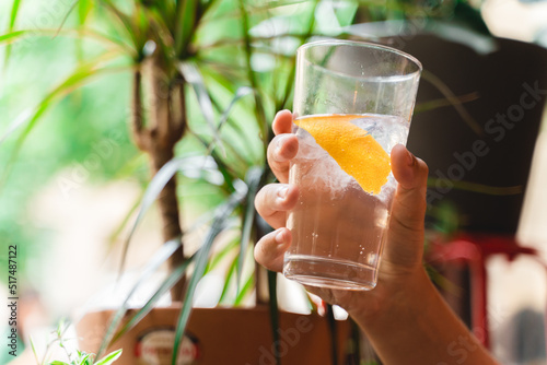 A close up of a hand holding gin and tonic