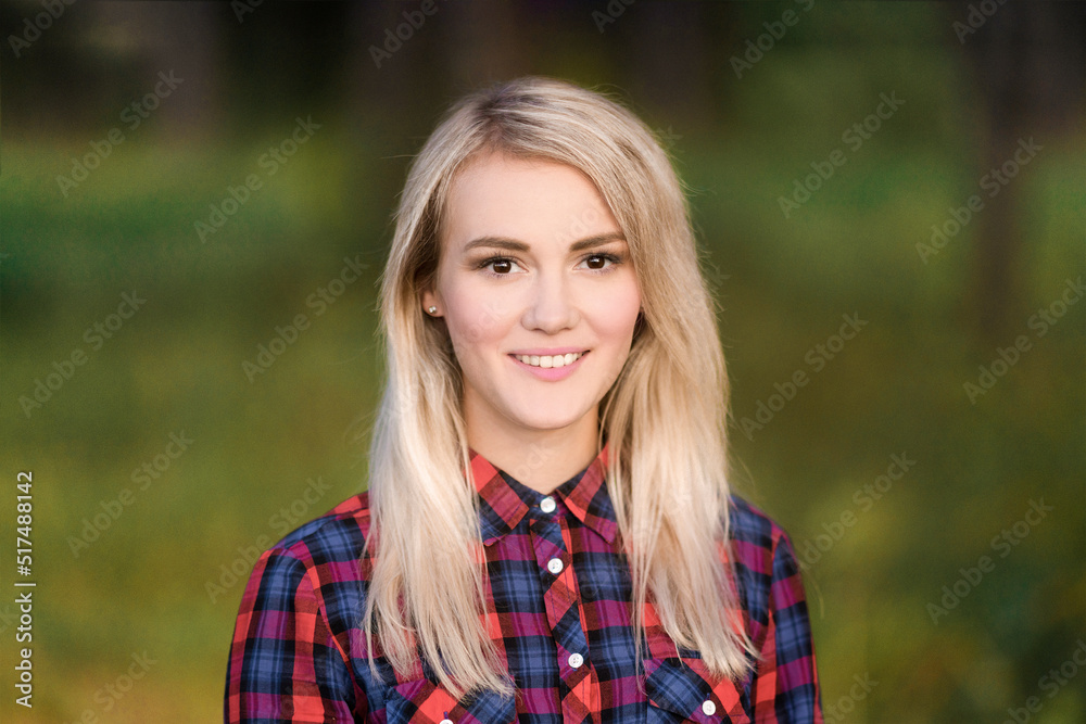 A portrait of a blond young woman smiling outdoors. A portrait of a blond young woman smiling outdoors.
