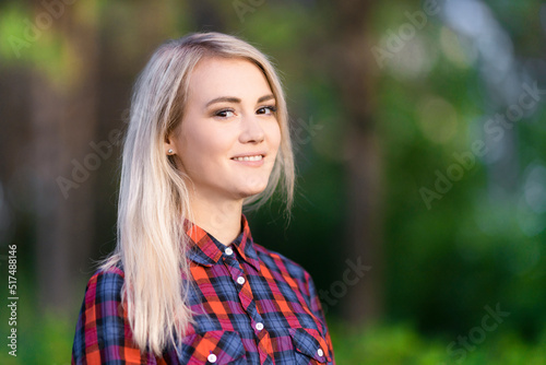A portrait of a beautiful smiling girl in the park.