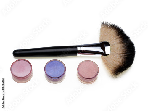 Professional natural makeup fan brush, colored eye shadows in a round package, on a white background, isolated