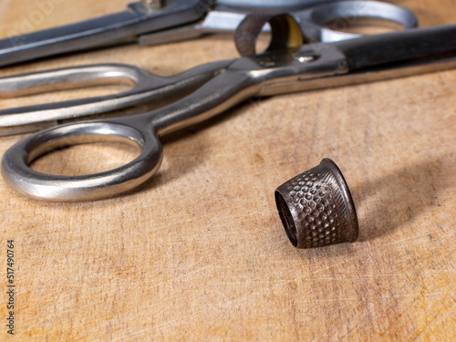 Metal Vintage thimble on wooden board fancy-work concept.