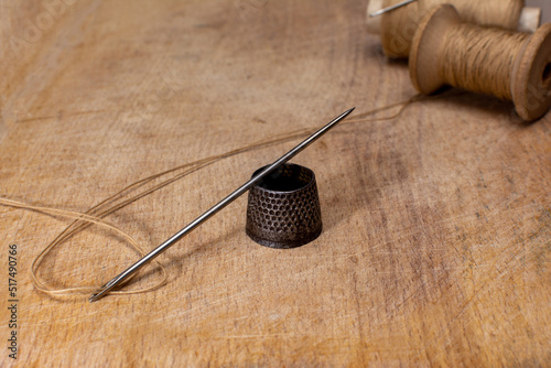 Fotografija Metal Vintage thimble on wooden board fancy-work concept