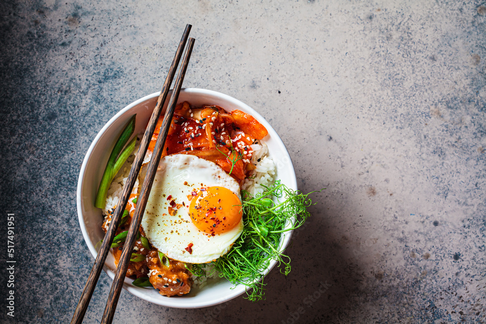 Bibimbap - meat, rice, kimchi, egg and sprouts in white bowl. Traditional Korean food. Bibimbap - meat, rice, kimchi, egg and sprouts in white bowl. Traditional Korean food.