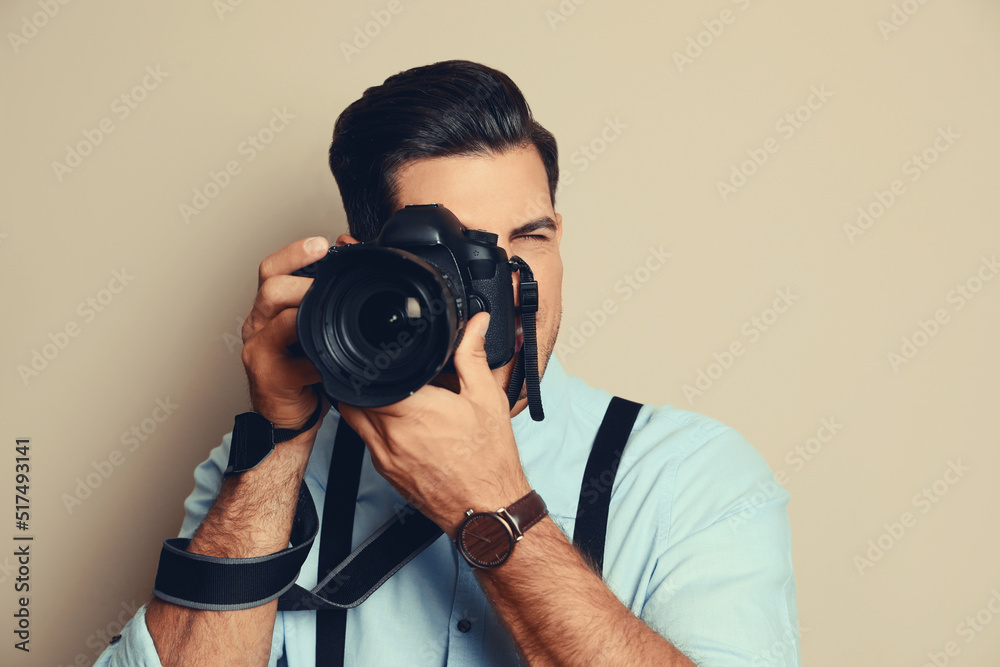 Professional photographer with camera on beige background Professional photographer with camera on beige background