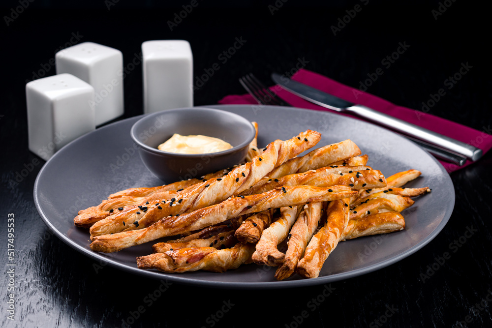 Breadsticks with cheese delicious snack. Grissini with cheese on a gray plate Breadsticks with cheese delicious snack. Grissini with cheese on a gray plate