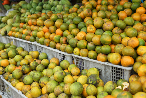 oranges and neat arrangement of fruit in baskets at the traditional market. healthy and fresh orange fruit background