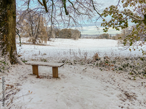 A seat looking over the English countryside covered in winter snow
