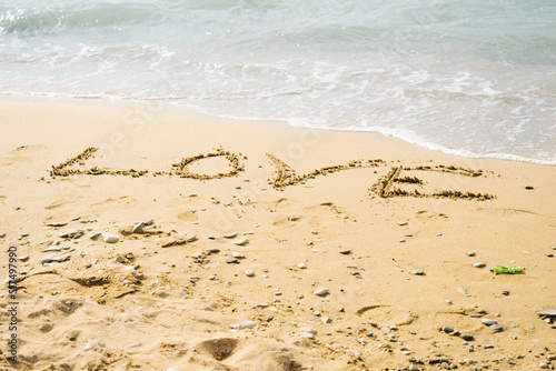 Word love written on the beach. Signs on the beach sand.