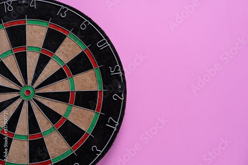 target dart board on the pink table background, center point, head to target marketing and business success concept