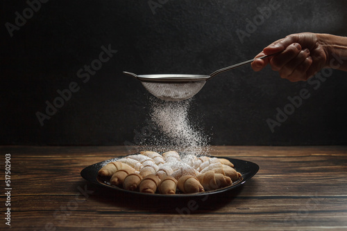Foto Fresh mini croissants sprinkled with powdered sugar