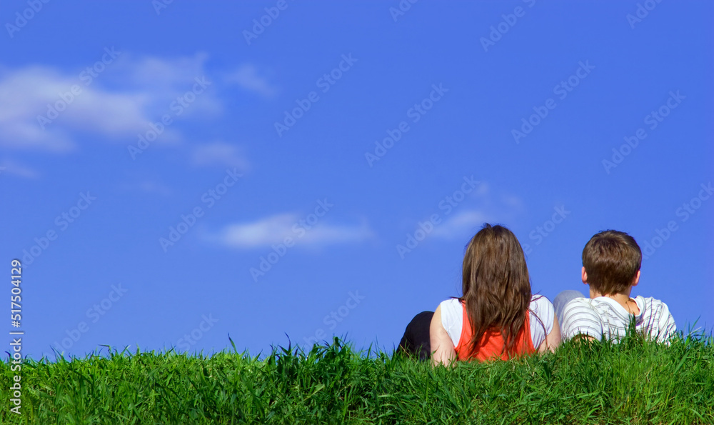 Back view of Romantic Couple in love sitting on grass field and watch the clear blue sky. Couple love dating in holiday trip concept. Back view of Romantic Couple in love sitting on grass field and watch the clear blue sky. Couple love dating in holiday trip concept.
