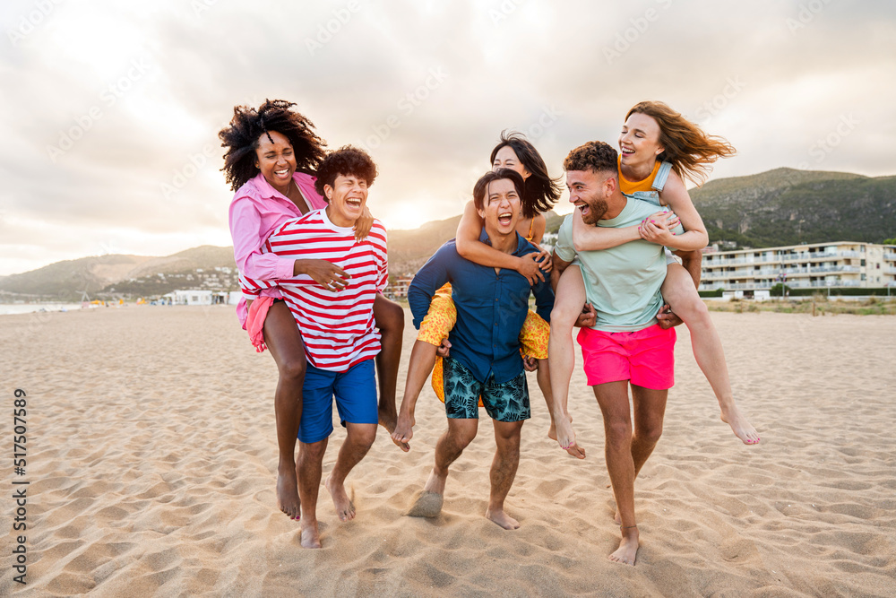 Group of young best friends bonding outdoors - Multiracial people bonding and having fun at the beach during summer vacation Group of young best friends bonding outdoors - Multiracial people bonding and having fun at the beach during summer vacation