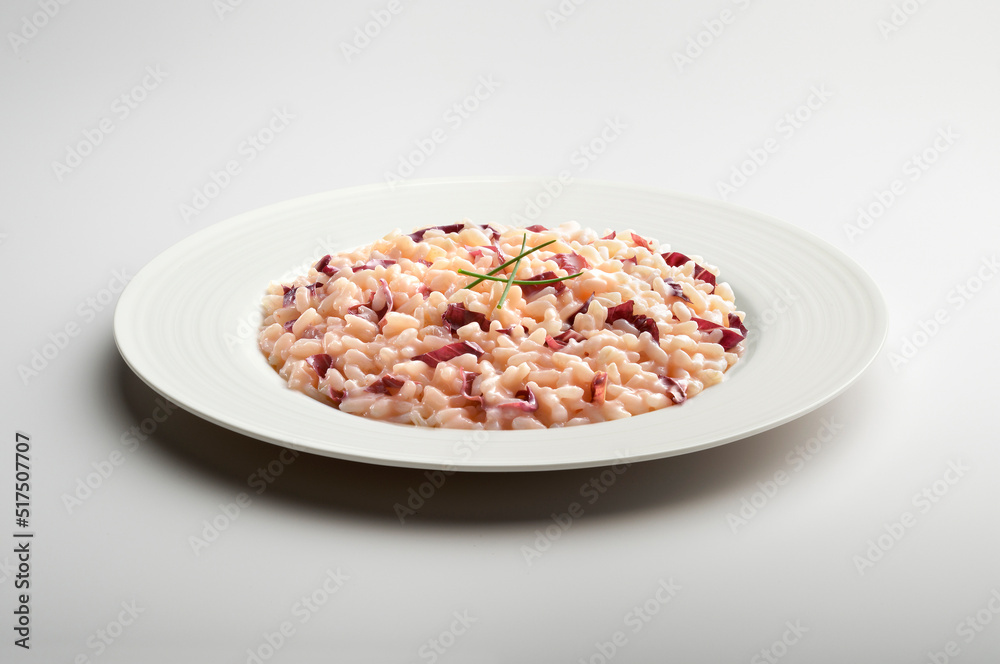 Risotto with Treviso red radicchio and chives in white plate Risotto with Treviso red radicchio and chives in white plate