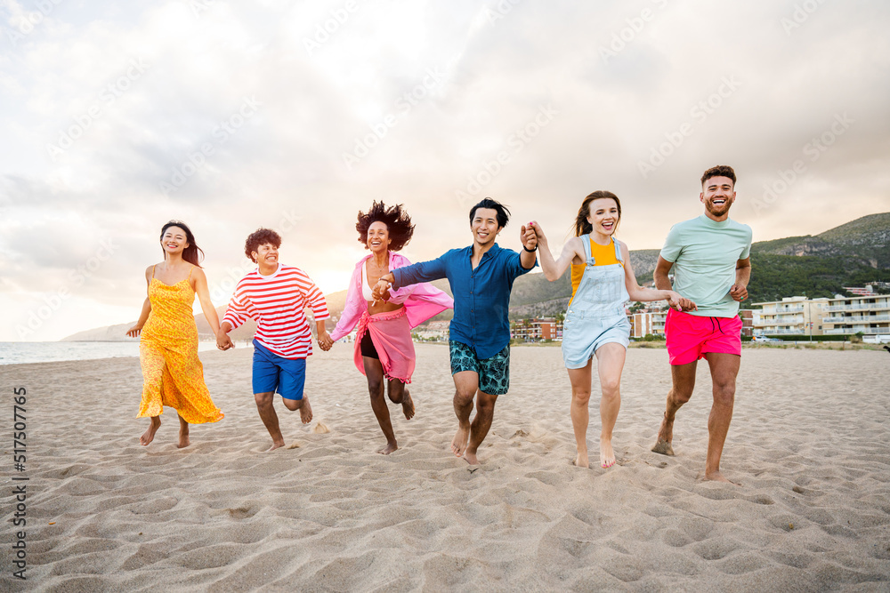 Group of young best friends bonding outdoors - Multiracial people bonding and having fun at the beach during summer vacation Group of young best friends bonding outdoors - Multiracial people bonding and having fun at the beach during summer vacation